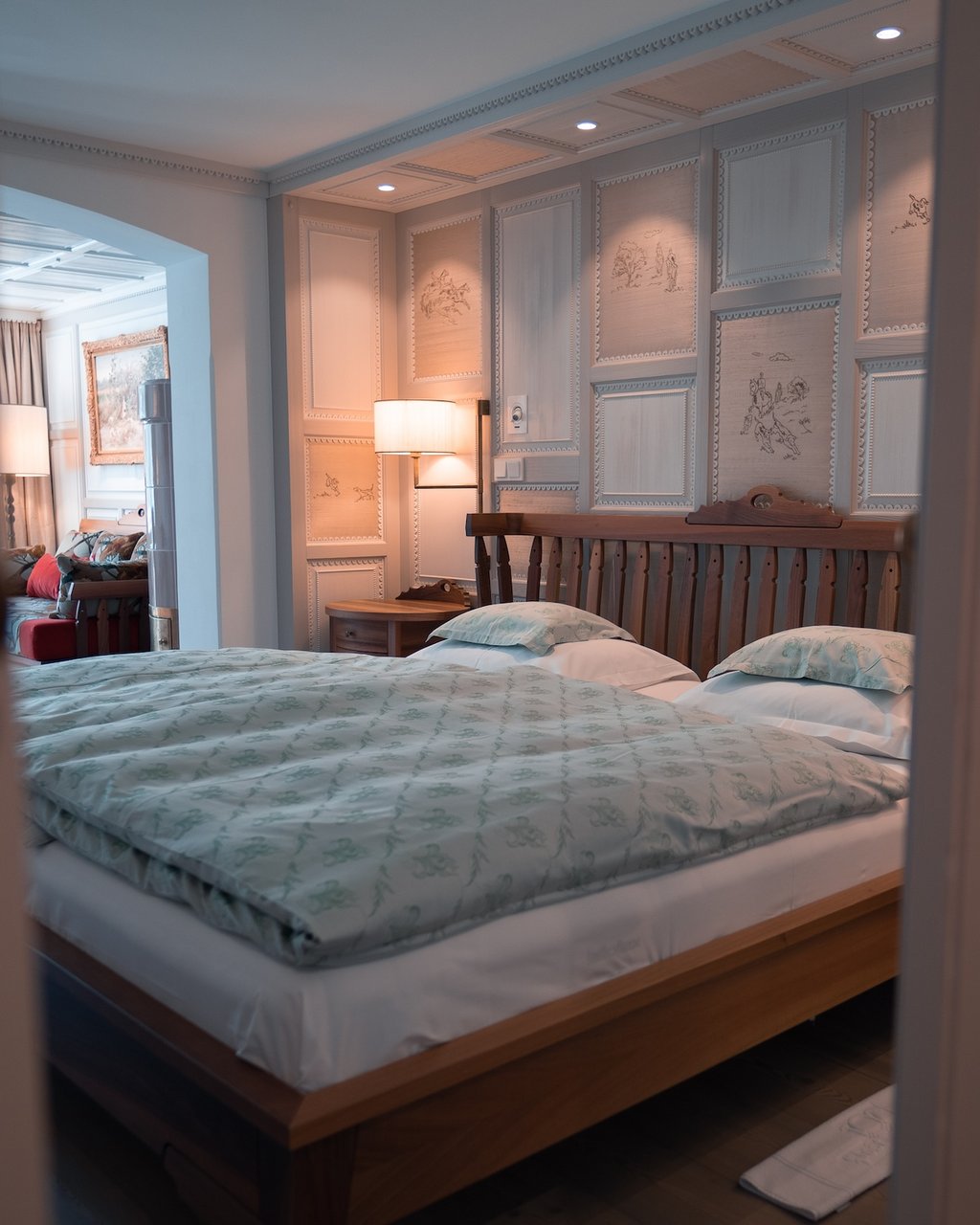 Bett in einem stilvoll eingerichteten Schlafzimmer mit dekorativer Wandvertäfelung