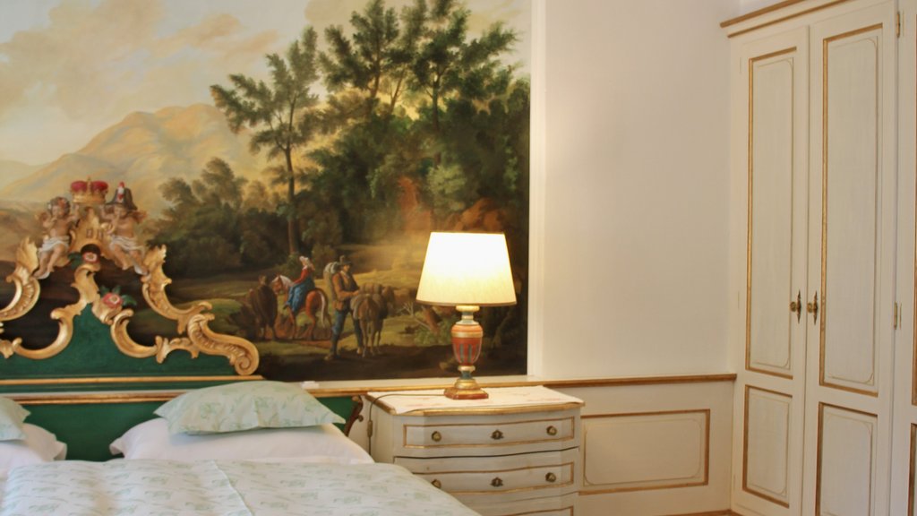 Elegant bedroom with green-gold antique bed and mural on the wall