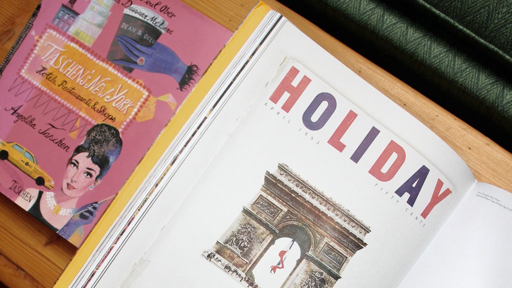 Aufgeschlagene Magazine mit Paris-Artikel auf einem Holztisch