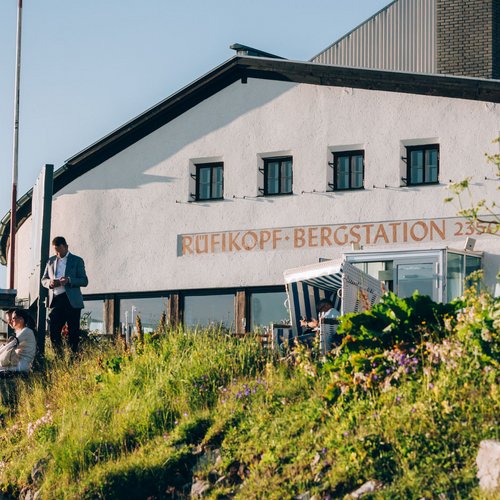 Sehenswertes am Arlberg | Hotel Post Lech Bergstation Rüfikopf mit zwei Personen auf einem blumenbewachsenen Hang