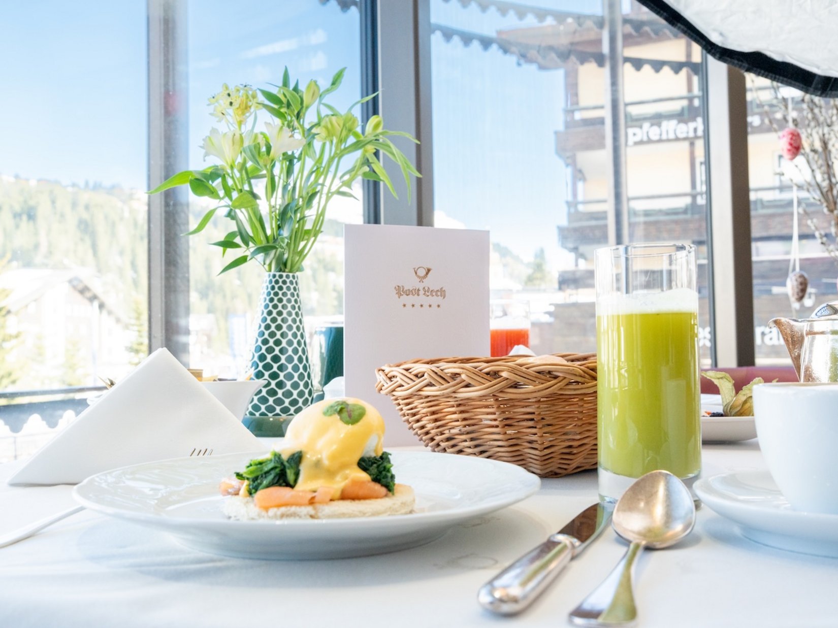 Elegant breakfast by the window with mountain view and fresh flowers