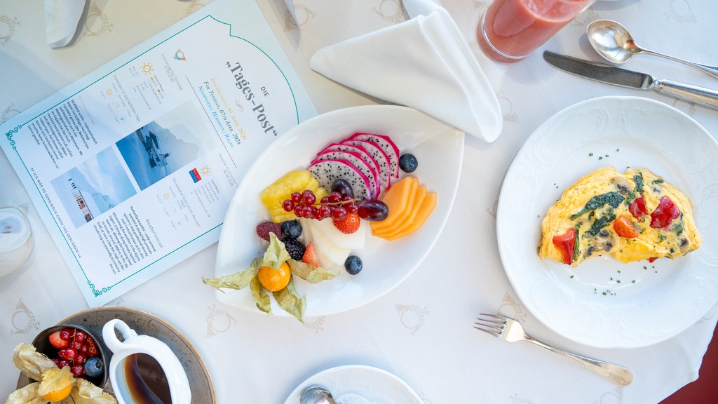 Breakfast table with omelette, fruit, juice and a daily newspaper.