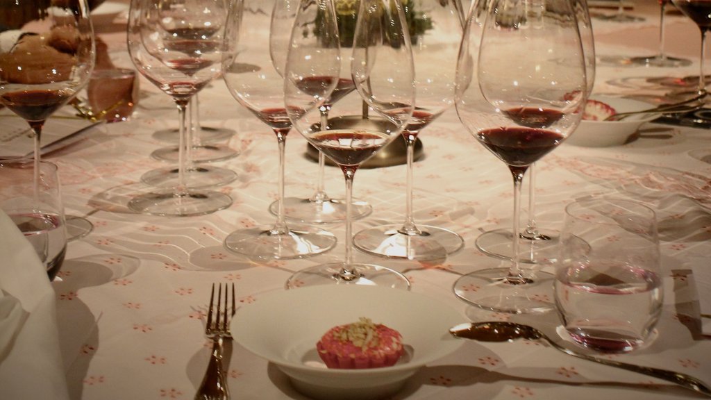 Wine glasses with red wine on a set table under dim lighting