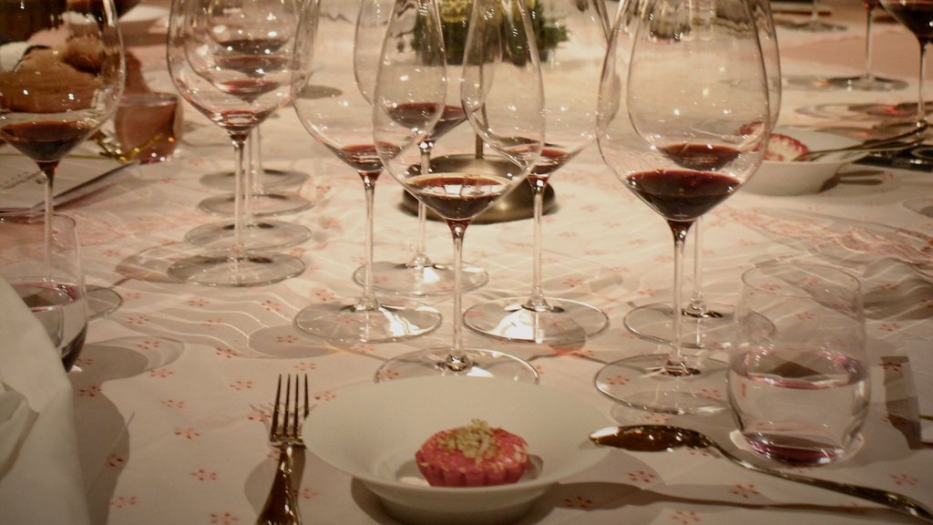 Weingläser mit rotem Wein auf einem gedeckten Tisch bei gedimmtem Licht