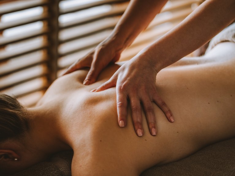Person erhält Rückenmassage mit Händen in ruhiger Umgebung
