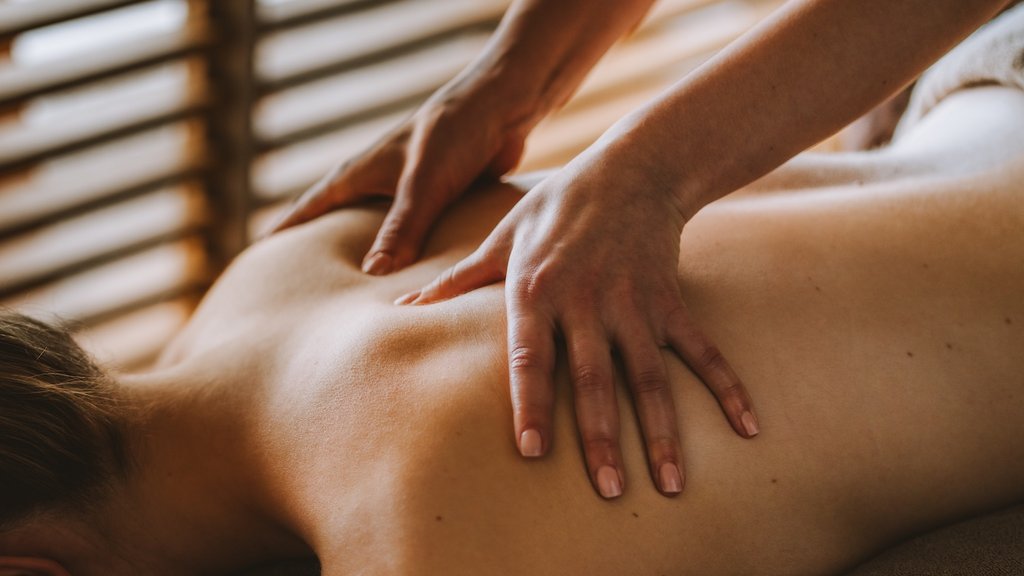 Person erhält Rückenmassage mit Händen in ruhiger Umgebung