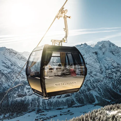 Sehenswertes am Arlberg | Hotel Post Lech Moët-&-Chandon-Gondel vor verschneiten Bergen