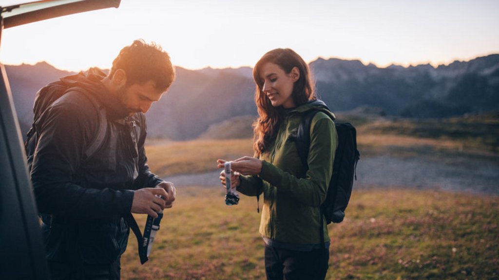 Wenn Ruhe zum Luxus wird Paar mit Rucksäcken bereitet sich bei Sonnenuntergang auf Wanderung vor