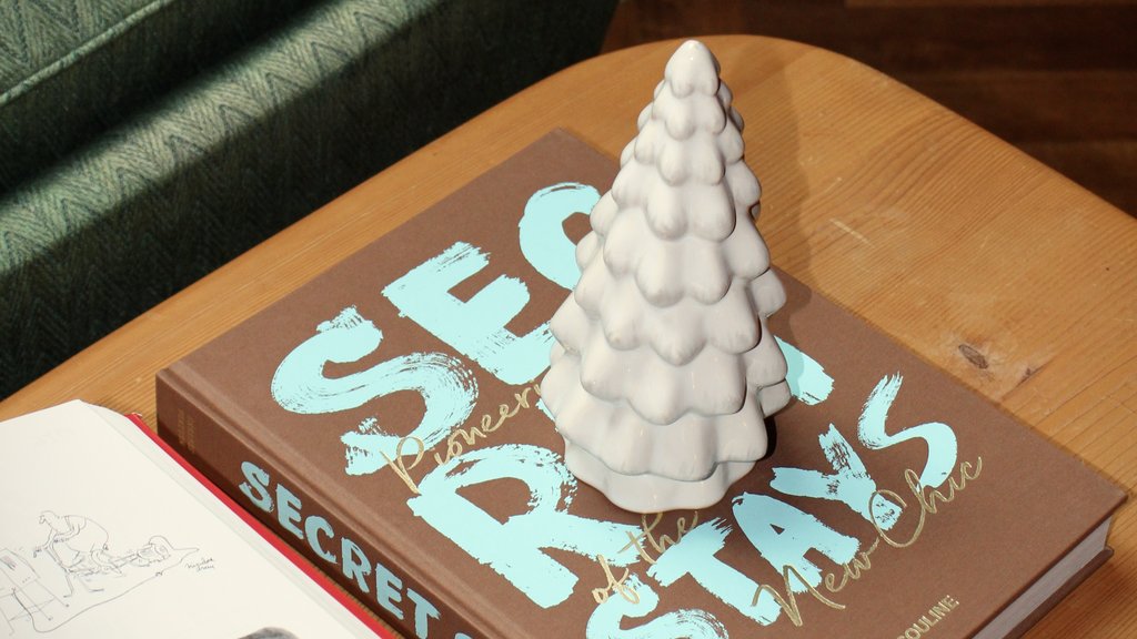 A new chapter in the "Hubertushalle" White Christmas tree figurine on a book beside an open magazine on a wooden table