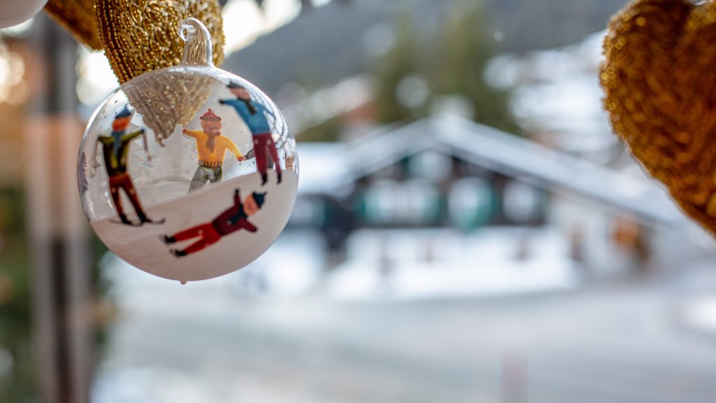 Adventzauber Glaskugel mit Weihnachtsmotiven und verschneitem Dorf im Hintergrund
