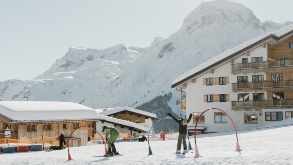 Skifahrer fährt auf schneebedeckter Piste in den Alpen bei klarem Himmel