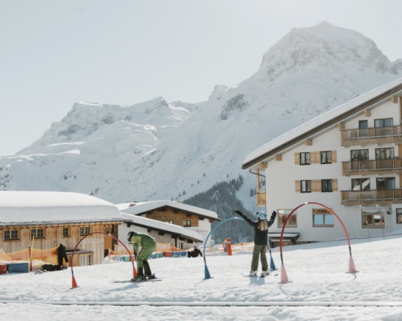 Skifahrer fährt auf schneebedeckter Piste in den Alpen bei klarem Himmel