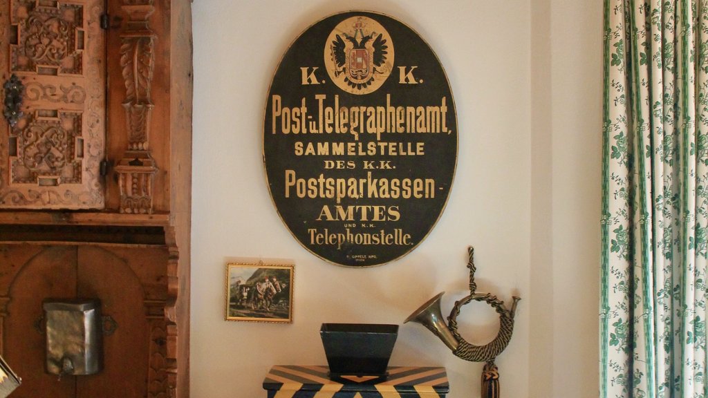Old post office sign, antique wooden furniture, and hunting horn on wall