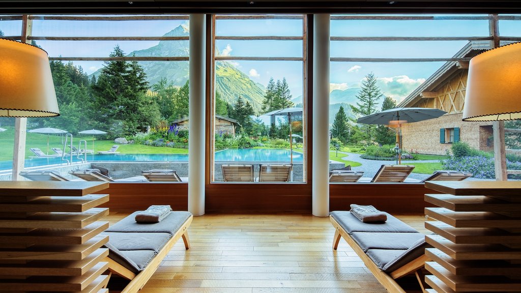 Blick aus einem Spa-Bereich auf einen Pool und Berge im Hintergrund