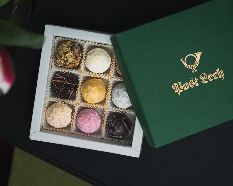 Offene Schachtel mit neun verschiedenen dekorierten Pralinen