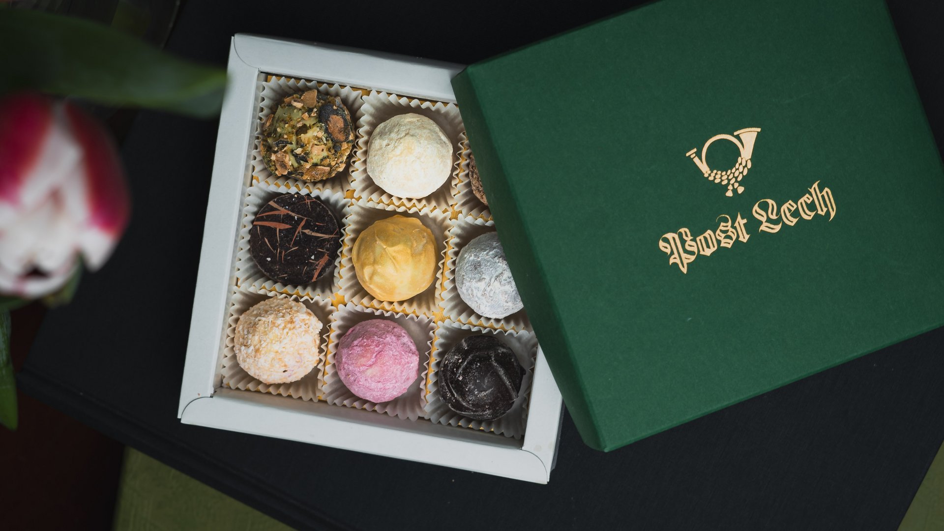 Open box with nine assorted decorated chocolate truffles