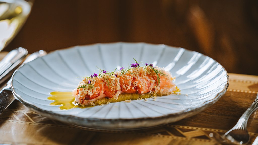 Indulge at Hotel Post Lech at the Arlberg | Alpine Luxury & Culinary Excellence Delicately plated shrimp with sauce and edible flowers on a white plate