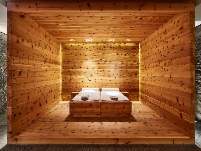 Wooden sauna with two lounge chairs and warm lighting