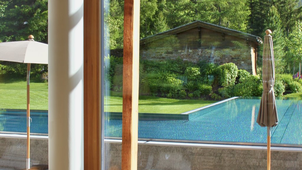 View through window of lounge chairs, pool and mountain landscape