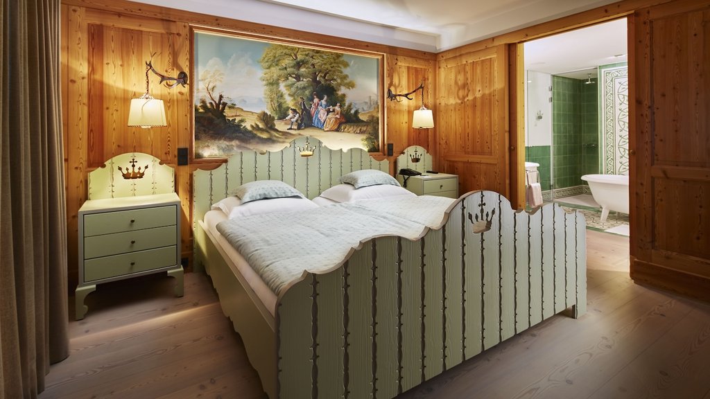 Gemütliches, holzgetäfeltes Schlafzimmer mit zwei Betten und Badezimmer in grün